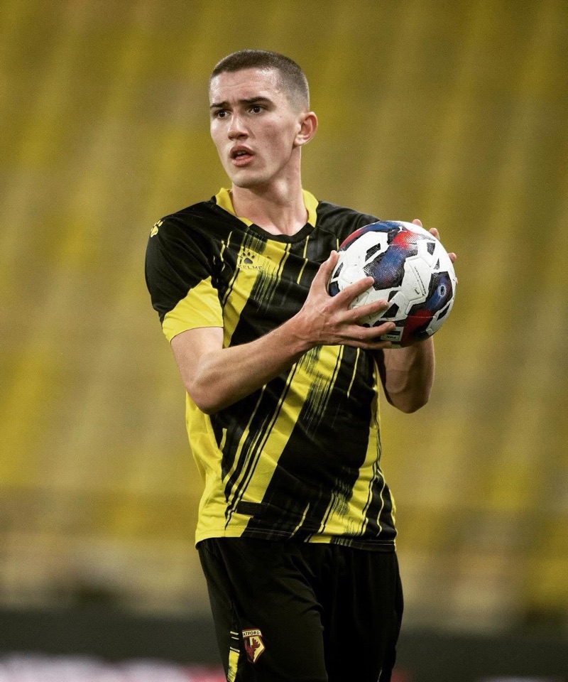 Ben Casey in Watford FC's yellow and black kit, holding the ball at Vicarage Road